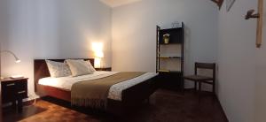 a small bedroom with a bed and a chair at Casa da Praia - Beach of Sand and Sea at the Door in Vila Praia de Âncora +7 photos
