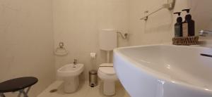 a white bathroom with a toilet and a sink at Casa da Praia - Beach of Sand and Sea at the Door in Vila Praia de Âncora
