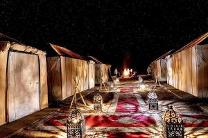 a room with a table with lights on it at night at Luxury Desert Camp with AC & Heating in Merzouga in Lac Yasmins