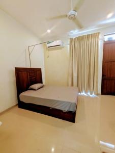 a small bedroom with a bed and a window at Villa Lovi Tree in Katunayake