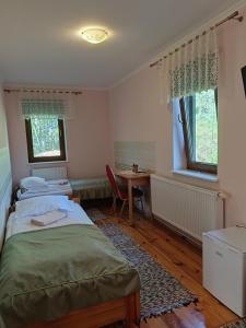 a bedroom with two beds and a desk and a table at Agroturystyka,Noclegi,Pokoje Gościnne,Usługi Agroturystyczne,Wyżywienie in Wydmusy