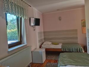 a small room with two beds and a window at Agroturystyka,Noclegi,Pokoje Gościnne,Usługi Agroturystyczne,Wyżywienie in Wydmusy
