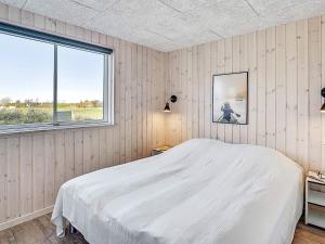 a bedroom with a white bed and a window at 5 star holiday home in Idestrup in Bøtø By