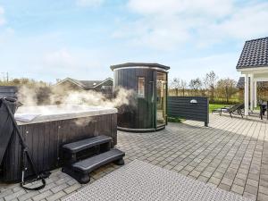 a hot tub with smoke coming out of it on a patio at 5 star holiday home in Idestrup in Bøtø By +35 photos