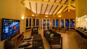 a living room with a television and a couch and a table at Villa Verde · Pool · Guesthouse · Ping Pong in Jan Thiel