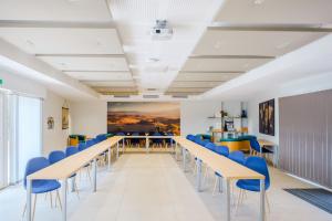 a conference room with tables and blue chairs at Le Mas du Lingousto in Cuers