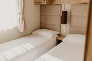 two beds in a small room with a window at Lower Cliff 8 in Portland