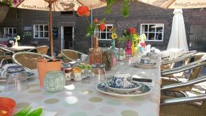 a long table with plates and vases on it at Brigidahoeve in Maastricht