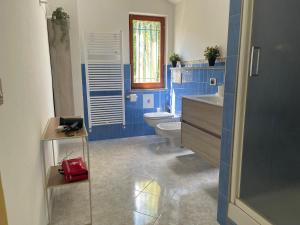 a blue bathroom with a toilet and a red purse at A 2 Colli dal Mare in Varazze +26 photos