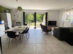 a kitchen and living room with a table and chairs at Au Moryllon in Lompnas