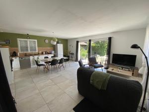 a living room with a couch and a table with chairs at Au Moryllon in Lompnas