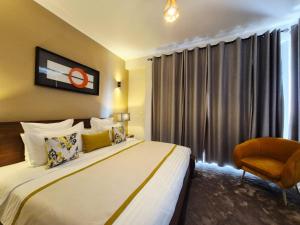 een hotelkamer met een bed en een stoel bij Andriana Luxury in Antananarivo