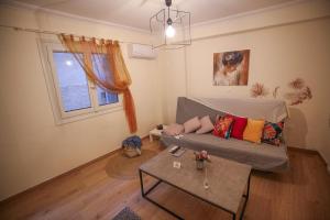 a living room with a couch and a table at Sunny Garden Apartment in central kolonaki Athens in Athens