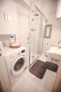 a bathroom with a washing machine and a shower at Sunny Garden Apartment in central kolonaki Athens in Athens