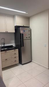 a kitchen with a refrigerator with magnets on it at Apartamento confortável in Manaus