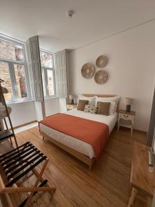 a bedroom with a large bed and two windows at Casa Tawny in Pinhão