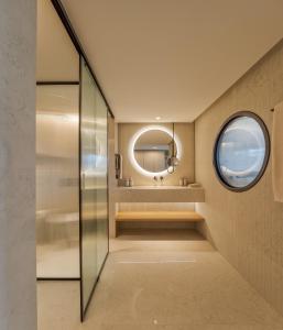 a bathroom with a round mirror and a sink at MACAM Hotel in Lisbon