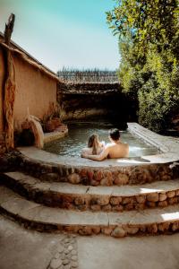 a man and a woman sitting in a pool of water at Hotel Don Raul in San Pedro de Atacama