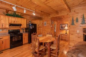a kitchen and dining room with a table in a cabin at Dreams Do Come True by American Patriot Getaways in Cartertown