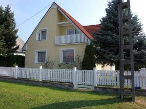 una staccionata bianca davanti a una casa di Apartments in Felsopahok - Balaton 19019 a Felsőpáhok