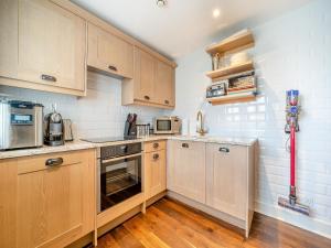 a small kitchen with wooden cabinets and appliances at Lundin Links - Ukc6916 in Turnberry