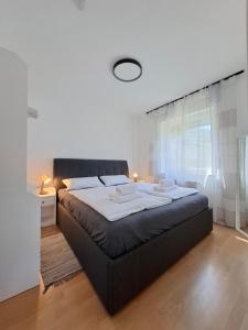 una camera da letto con un letto grande con lenzuola bianche di Villa Auszeit im Haus Auszeit im Weindorf 1 BR up to 4 people a Leinsweiler
