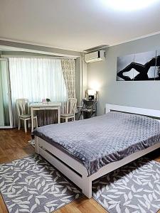 Un dormitorio con una cama y una mesa y sillas. en Lux apartment Prospect Central, en Mykolaiv