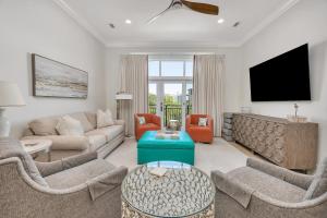 a living room with a couch and a tv at Sea Point #205 in Saint Simons Island