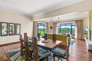 LinksView at Pezula في كنيسنا: غرفة طعام مع طاولة وكراسي وغرفة معيشة