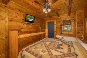 a log cabin bedroom with a television and a tub at Dukes Den by American Patriot Getaways in Cartertown