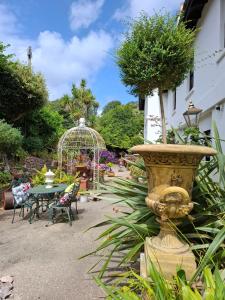a garden with a fountain and a table and chairs at Palm Grove Apartments in Torquay