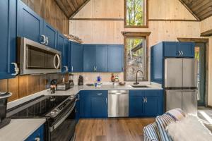 een keuken met blauwe kasten in een houten huis bij Anchors Retreat - Lakefront Getaway for 14 Guests in Sevierville +18 foto's