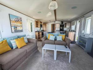a living room with a couch and a table at Beautiful Caravan With Decking At Carlton Meres Holiday Park, Suffolk Ref 60022M in Saxmundham