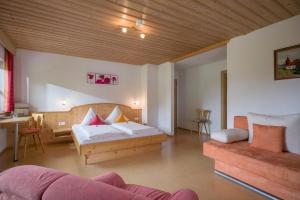 a bedroom with a bed and a couch in a room at Wanishof in Thiersee