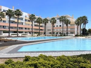 a large swimming pool in front of a large apartment building at Lux Apt in Priv Condo with Pool, near Beach, Parking & Easy Access to Lisbon in Parede