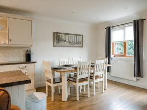 a kitchen and dining room with a table and chairs at Fir Tree Lodge in Sewerby