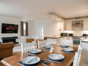 a kitchen and dining room with a wooden table and chairs at Fir Tree Lodge in Sewerby