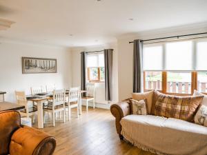 a living room with a couch and a dining room at Fir Tree Lodge in Sewerby