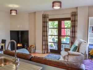 a living room with a couch and a fireplace at Lime Tree Cottage in Drumpark