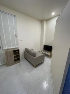 a living room with a couch and a television at Sairin 1 bedroom BTS Udomsuk in Bangna