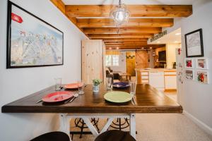 a dining room with a table and a kitchen at Cozy Condo, Minutes from Sunday River in Bethel +14 photos
