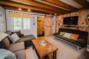 a living room with a couch and a table at Cozy Condo, Minutes from Sunday River in Bethel