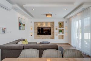 ein Wohnzimmer mit Sofa und Tisch in der Unterkunft Villa Zlatne NiTi with heated pool in Kaštela