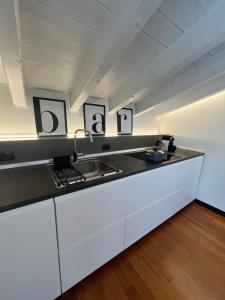 a kitchen with white cabinets and a sink at Studio21 Monza in Monza