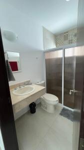 a bathroom with a toilet and a sink and a shower at Casa Moderna en Fraccionamiento in Caucel +28 photos