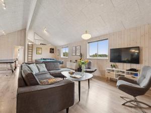 a living room with a couch and a tv at 5 star holiday home in Spøttrup in Spottrup +37 photos