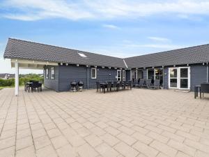 een gebouw met een patio met tafels en stoelen bij Luxury Retreat by Hostrup Beach - By Traum Ferienwohnungen in Spottrup