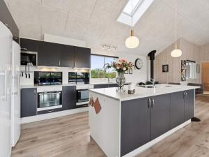 a kitchen with black cabinets and a white counter top at 5 star holiday home in Spøttrup in Spottrup