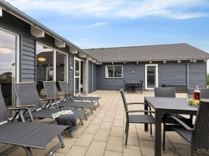 een patio met stoelen en tafels en een huis bij Luxury Retreat by Hostrup Beach - By Traum Ferienwohnungen in Spottrup