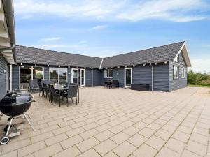 een patio met een grill en een huis bij Luxury Retreat by Hostrup Beach - By Traum Ferienwohnungen in Spottrup